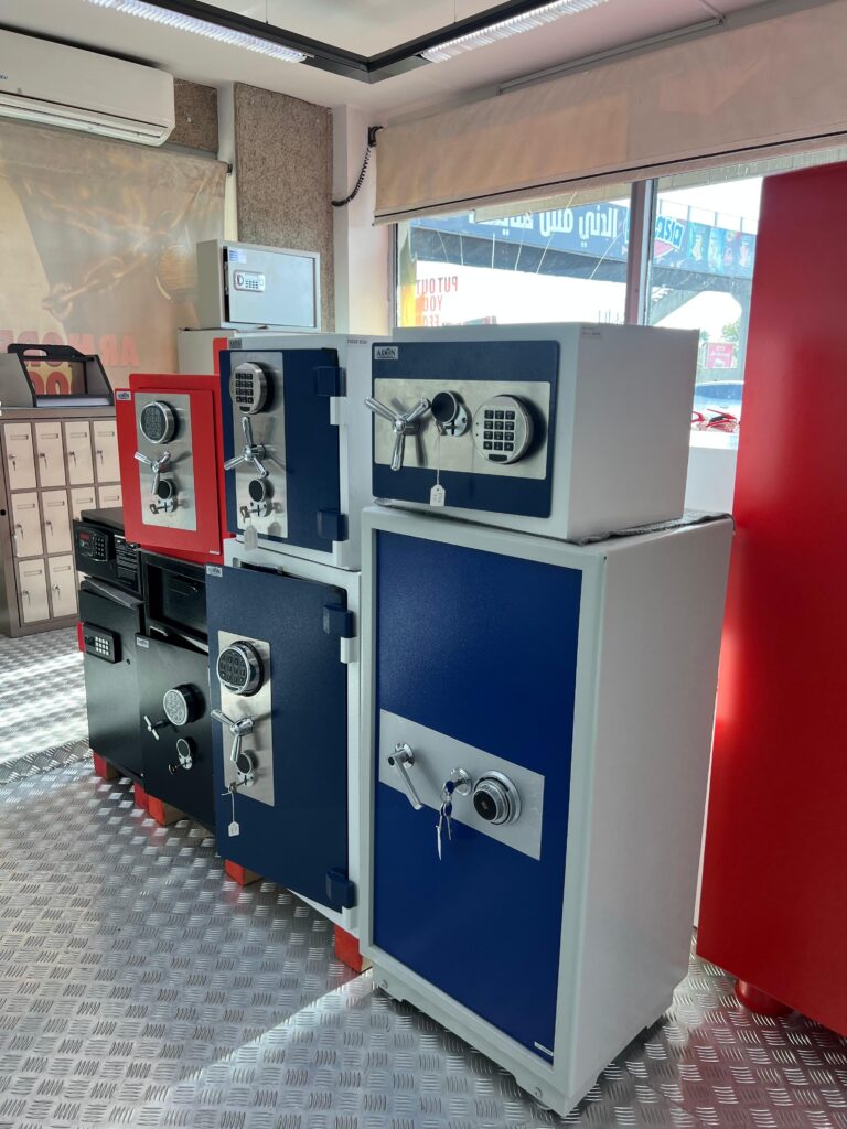 Multiple closed safes in blue, red, and black colors, designed for secure storage of valuables in homes and businesses.